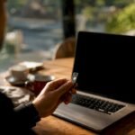 Hand holding security key near smartphone on desk