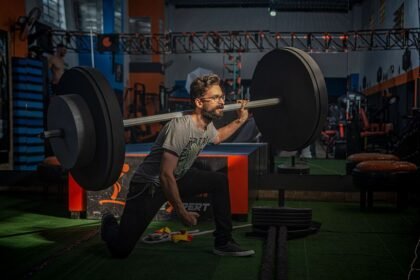 man performing barbell back squat in gym